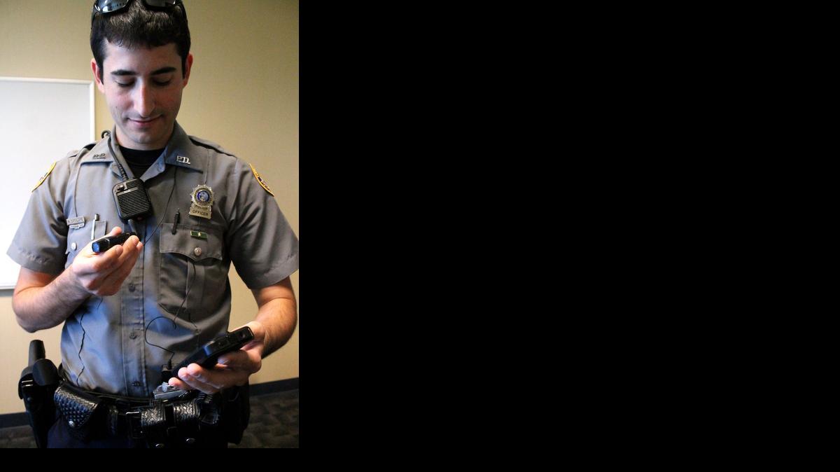 
El oficial Michael Catalano del Departamento de Policía de Daytona Beach muestra una de las cámaras que han comenzado a usar los agentes.



