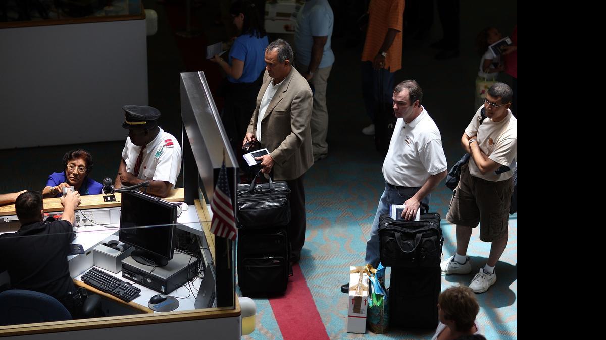 
Un agente de control de aduanas revisa los pasaportes y documentos de entrada de los viajeros en el Aeropuerto Internacional de Miami.

