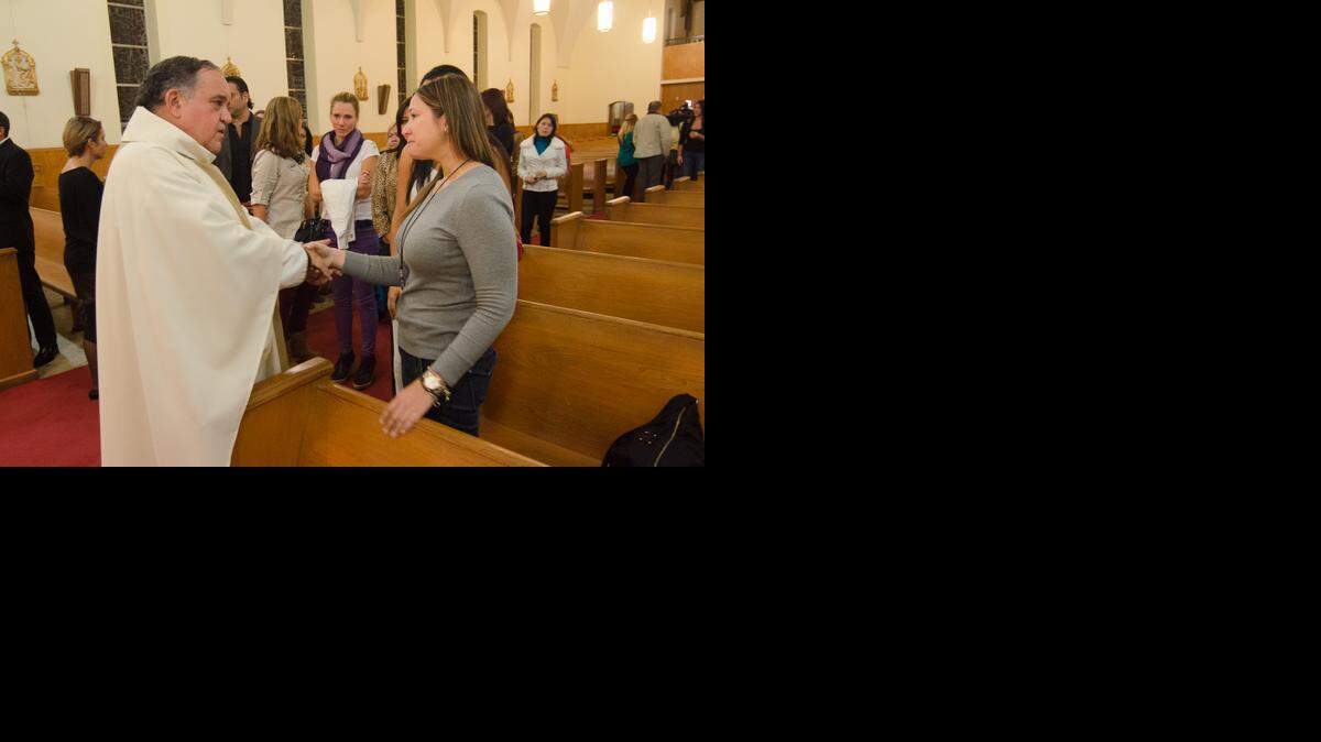 
El padre Juan M. López conforta a Ana Jimeno, familiar de Monica Spear en la misa celebrada el jueves en la iglesia St. Peter and Paul.
