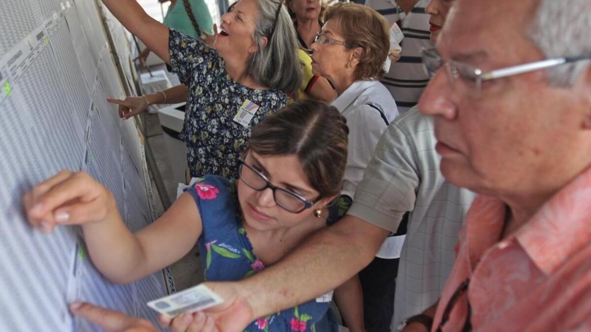 La voluntaria Miryam López, ayuda a un elector durante el plebiscito sobre el acuerdo de paz entre Colombia y las FARC, en Coral Gables.