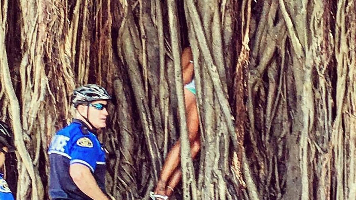 La foto muestra a la mujer atrapada, mientras dos oficiales de policía esperan por ayuda para liberarla