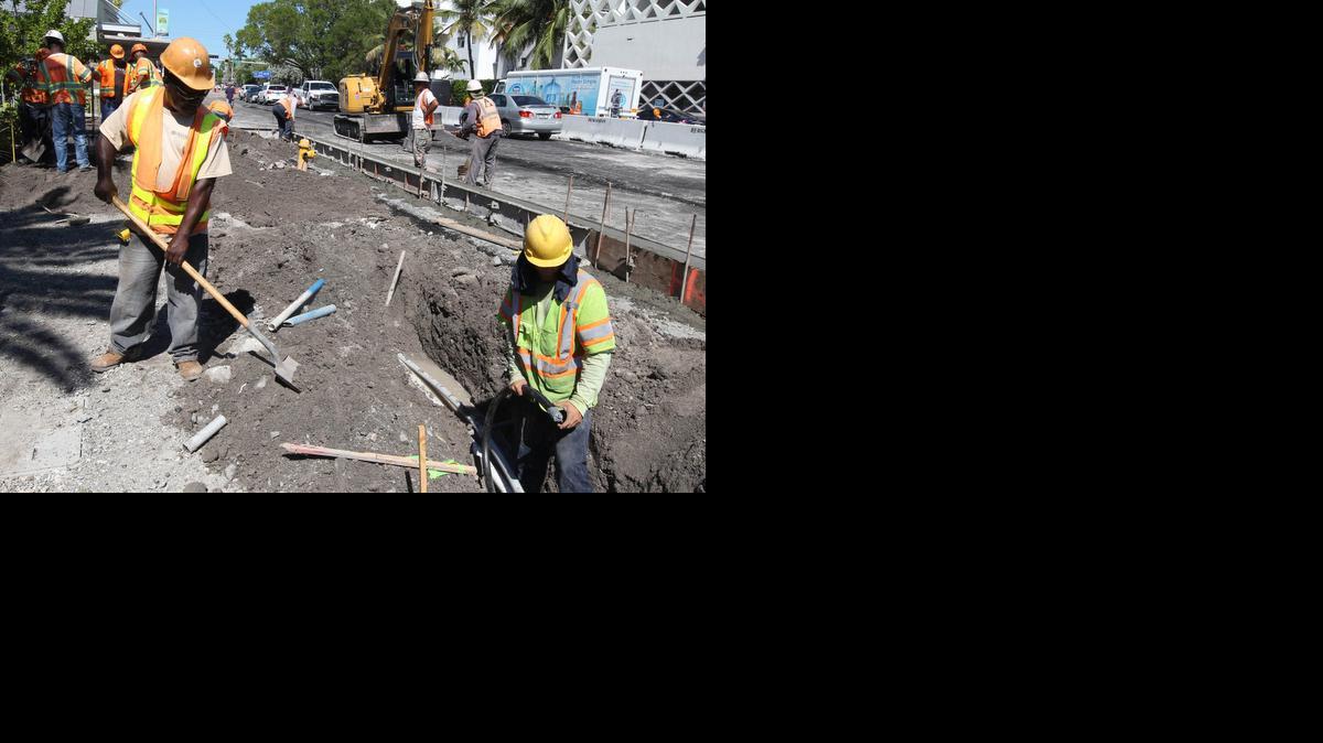 
Obreros de la construcción completan una nueva acera en Alton Road y la calle 10 de Miami Beach el pasado jueves.
