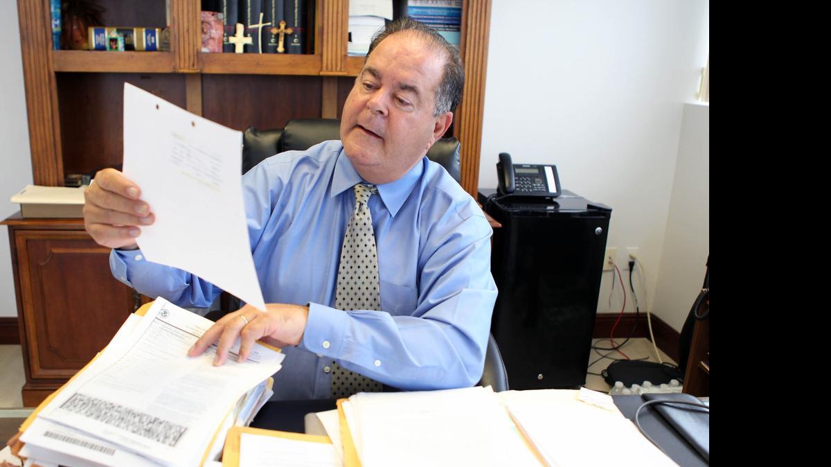 
El abogado Eduardo Soto observa los documentos del expediente de Miguel Romero Diaz en su oficina de Coral Gables.


