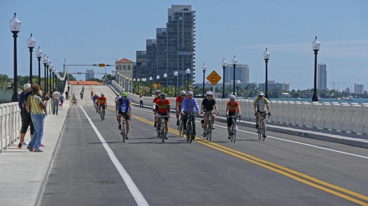 Ciclistas, incluyendo al alcalde de Miami-Dade, Carlos Giménez (centro), manejaron en dirección oeste a través del recién abierto puente el lunes.