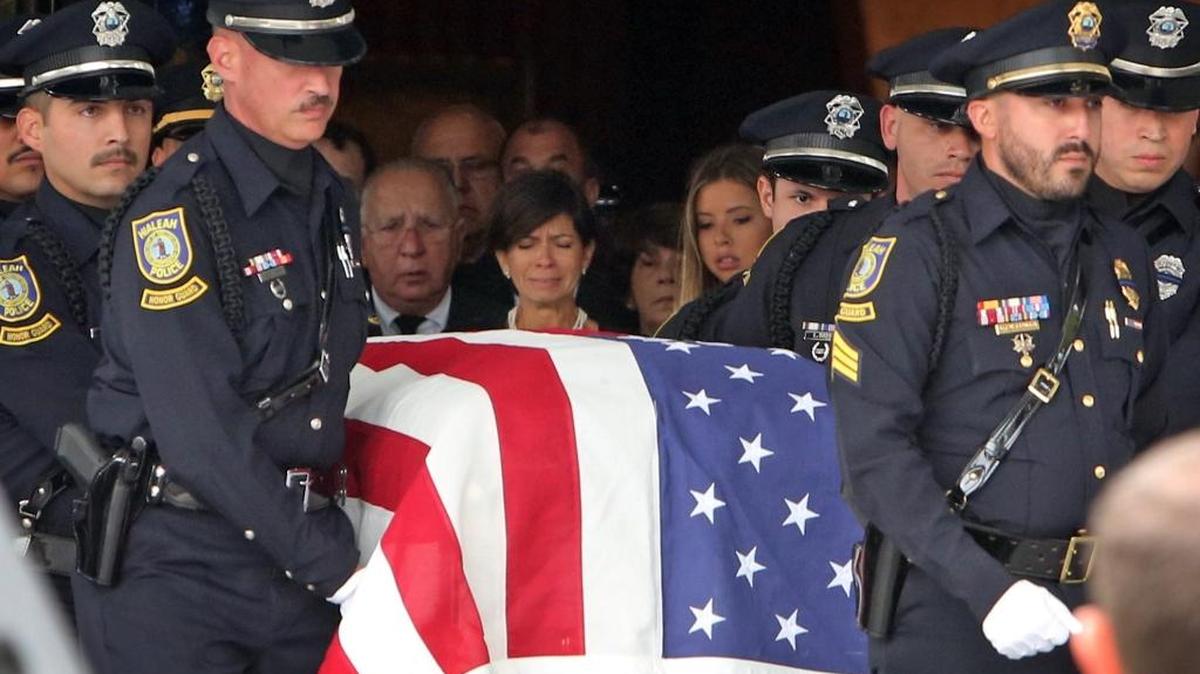 Esther, la viuda del jefe de la Policía de Bal Harbour, Mark Nathan Overton, llora el lunes cuando el ataúd con los restos de su esposo es trasladado desde la Iglesia Católica de la Inmaculada Concepción al cementerio.