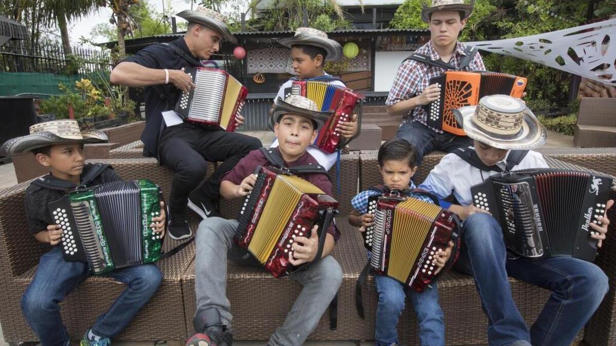 Carlos Cabrera, de 12 años; Yesid Salazar, de 13; Juan José Pallares, de 6; Sebastián Rodríguez, de 13 (frente de izq. a der.), Andrés Janer, de 20 años; Jose Caraballo, de 10, e Isaiah Nader, de 18, durante el II Festival Internacional de Acordeones, en el Parque de las Artes, Doral, este domingo.