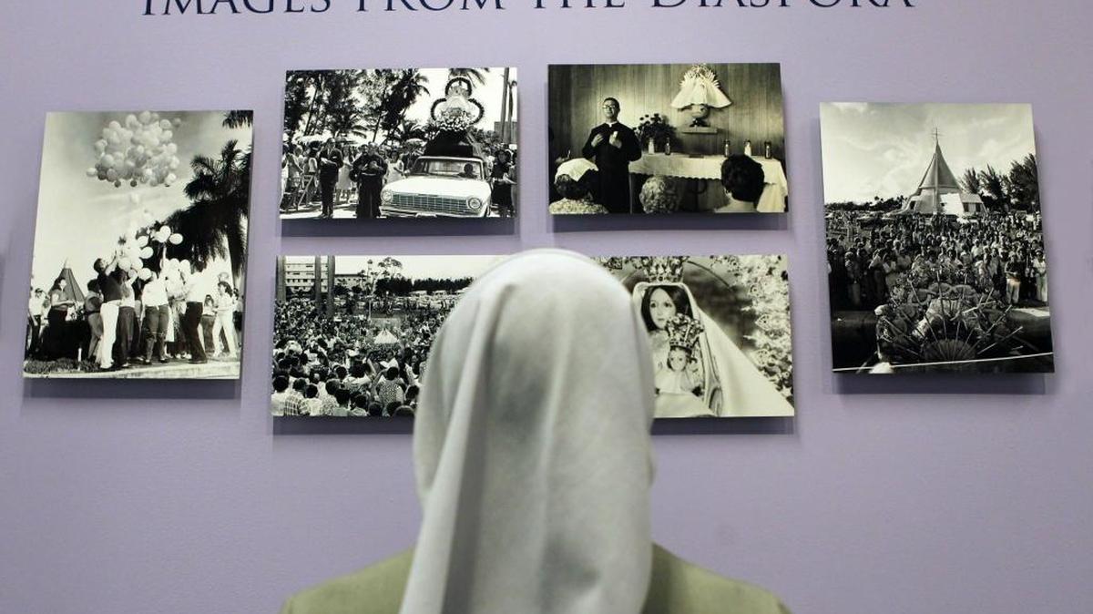 
La hermana Ondina Cortés observa algunas de la fotografías de la exhibición sobre la historia de la devoción a la Virgen de la Caridad del Cobre en Miami, en la Biblioteca de la Universidad Saint Thomas.
