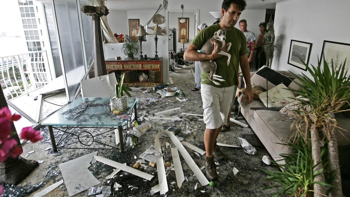 Daniel Sánchez, acompañado de su perro Leo, observa los daños en su aparamento en Grandview Palace, en North Bay Village, después del paso del huracán Vilma, en una imagen del 24 de octubre del 2005.