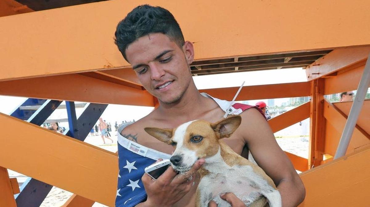 
Luis, uno de los 12 balseros cubanos que llegaron a las playas de Miami Beach el 15 de septiembre, muestra a “Chiquitica”, la perra que los acompañó en la travesía. 
