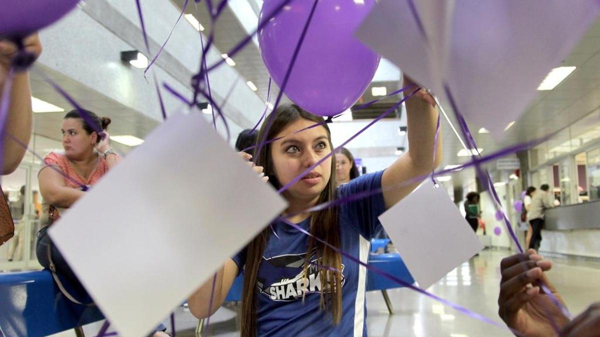 La estudiante Jennifer Rizo del Miami Dade College coloca el miércoles etiquetas con los nombres de las víctimas de la masacre de Orlando a globos.