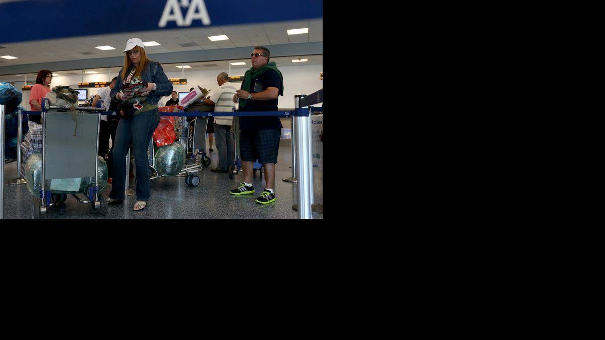 
Cargados de equipaje, los pasajeros para Cuba esperan su turno ante el mostrador de ABC Charters American Airlines, el viernes.


