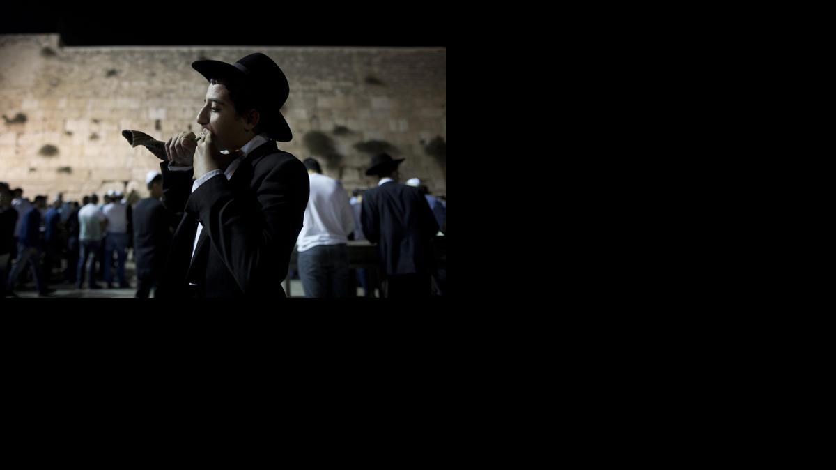 
 Un joven judío ultraortodoxo sopla un "shofar" durante la noche para los perdones (Selichot) en el Muro Oeste, el lugar más sagrado en el judaísmo, en la antigua ciudad de Jerusalén (Israel) hoy, miércoles 24 de septiembre de 2014, en el marco de la celebración del Nuevo Año Judío (Rosh Hashanah). EFE/ABIR SULTAN
