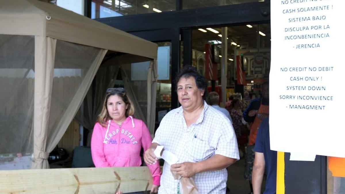 Dos clientes salen de la sucursal de Home Depot de la Calle Ocho y la 30 ave. del S.W. luego de haber pagado su compra en efectivo ya que el sistema no funcionaba este sábado.