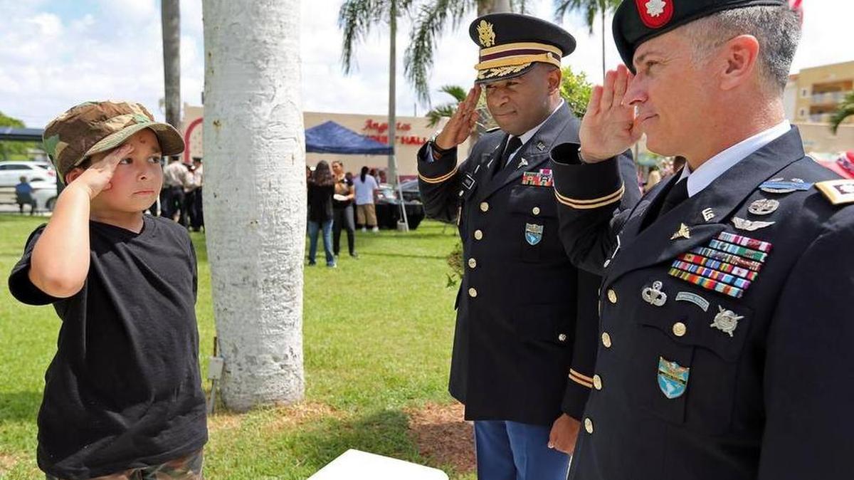 Gabriel Riera, de 5 años, saluda al mayor Rodney Hankins y al teniente coronel Michael Coote durante la ceremonia por el Día de la Recordación de la Ciudad de Hialeah, el lunes 25 de mayo de 2015.