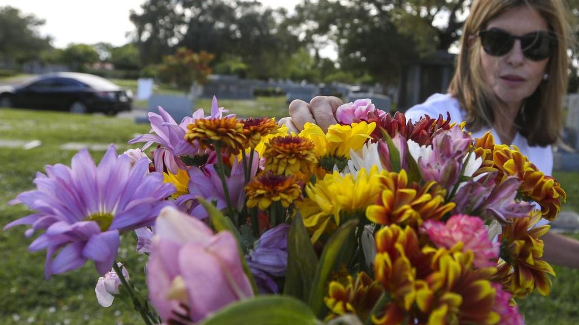 Ana Díaz Gutierrez coloca flores en la tumba de su familia en el cementerio Caballero Rivero Woodlawn North luego de escuchar la noticia de la muerte de Fidel Castro.