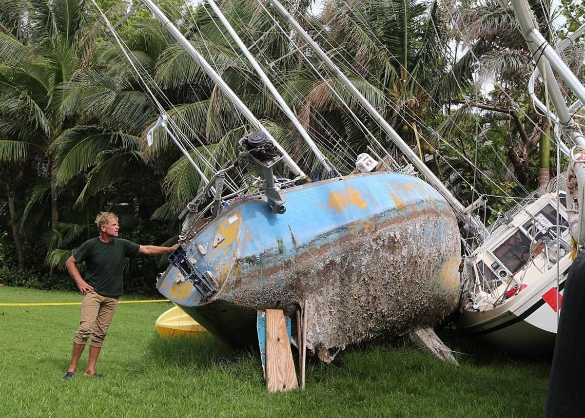 Chris Krupa junto a su velero, que fue a parar al patio de la casa de Jessica Ivler, en Coconut Grive, durante el huracán Irma.
