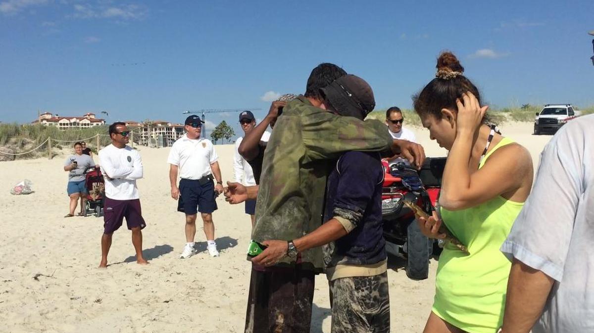 Inmigrantes cubanos se abrazan luego de llegar a una playa de Miami Beach, el lunes en la mañana.