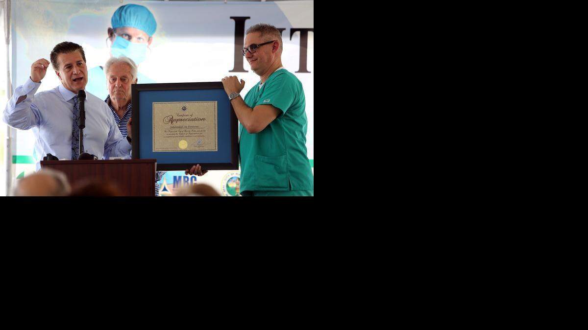 
El alcalde de Hialeah, Carlos Hernández (izq.), entrega al Dr. Julio César Alfonso, presidente de Solidaridad sin Fronteras (der.), un certificado de apreciación de la ciudad. Atrás, el comisionado José Caragol.

