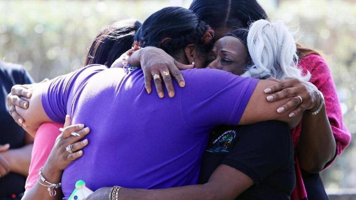 Los residentes de Arthur Mays Villas, en Miami-Dade, se consuelan durante una reunión en Goulds Park el sábado 16 de diciembre de 2017, un día después de que Carnelle Williams-Thomas muriera por una bala perdida.