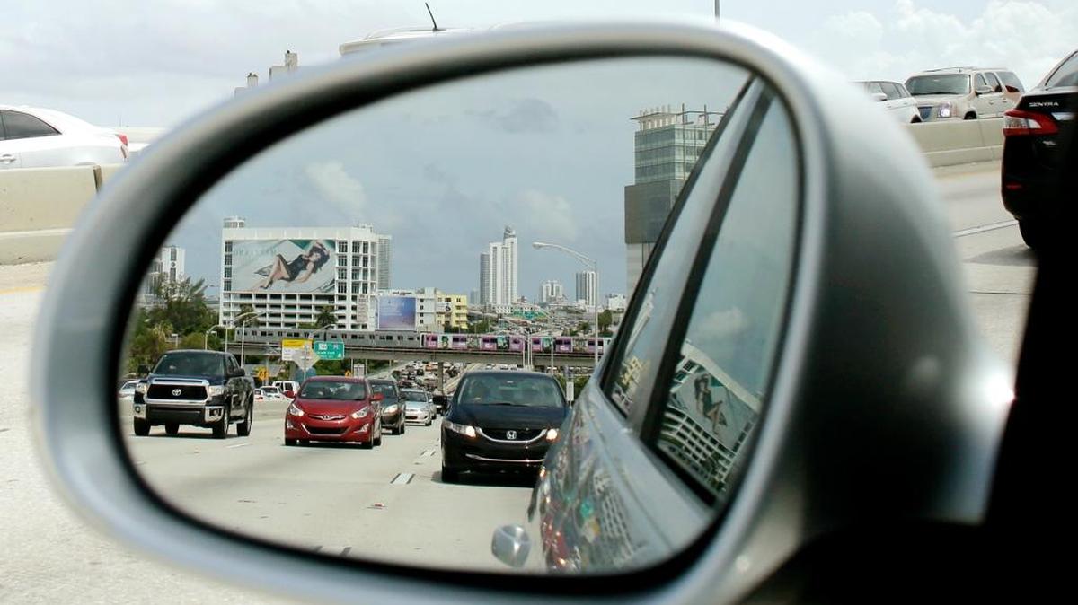 Vista desde el espejo retrovisor de un automóvil que circula por una autopista en el downtown de Miami, el 1 de julio del 2016.