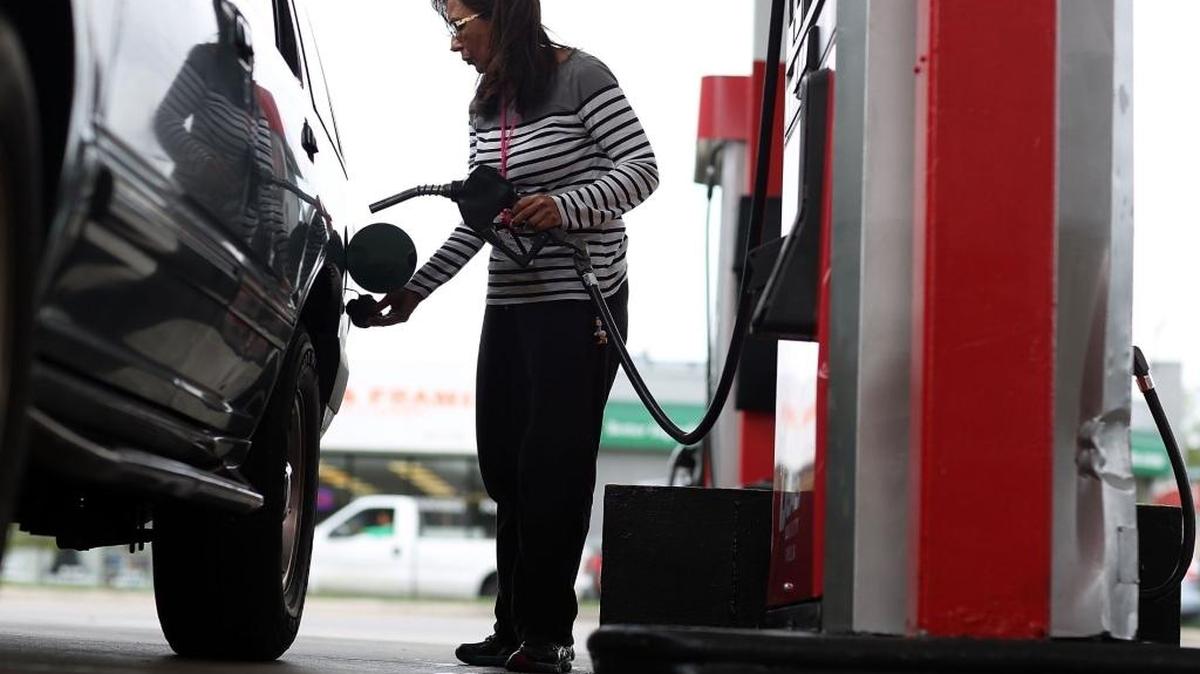 Josephina Romano llena el tanque de su vehículo en una gasolinera U-Gas de Miami, el 19 de octubre del 2015.