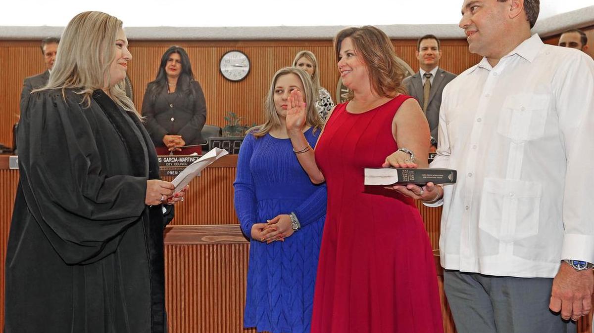 La jueza Victoria Ferrer juramenta a la concejal Vivian Casals-Muñoz en el Ayuntamiento de Hialeah. La acompañan familiares.