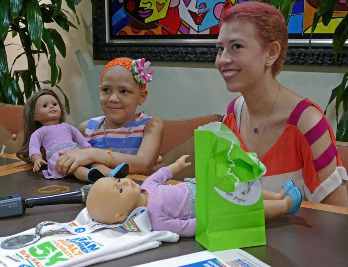 Georgina, una niña con cáncer, y Raquel Coronell, a los 17 años y también con cáncer, con muñecas American Girl calvas en el Nicklaus Children’s Hospital el 11 de marzo de 2016.