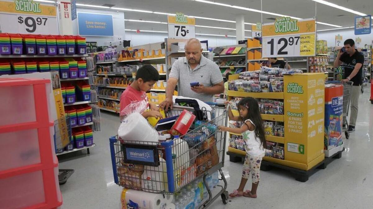 Melvin Trochez con sus hijos adquiere los útiles escolares en una tienda de Walmart Doral el martes. Los floridanos tienen tres días para comprar ropa y útiles escolares sin pagar impuestos.