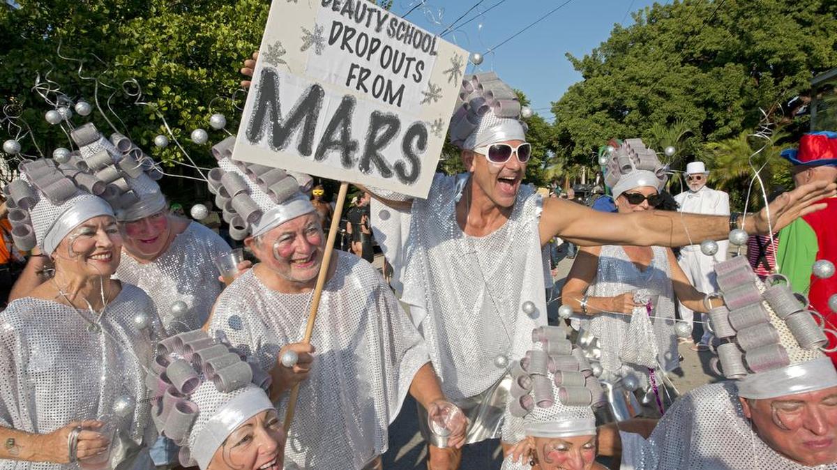 En esta foto de Viernes 30 de octubre 2015, proporcionada por la Oficina de Noticias de Florida Keys, criaturas del espacio caminan por la calle Fleming en Key West, Florida. durante la marcha de máscaras del ‘Fantasy Fest’.