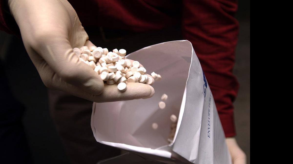 
Un funcionario sostiene algunas de las tabletas de la droga Ecstasy que fueron encontradas escondidas en el fondo falso de una caja de empaque en el 2006.


