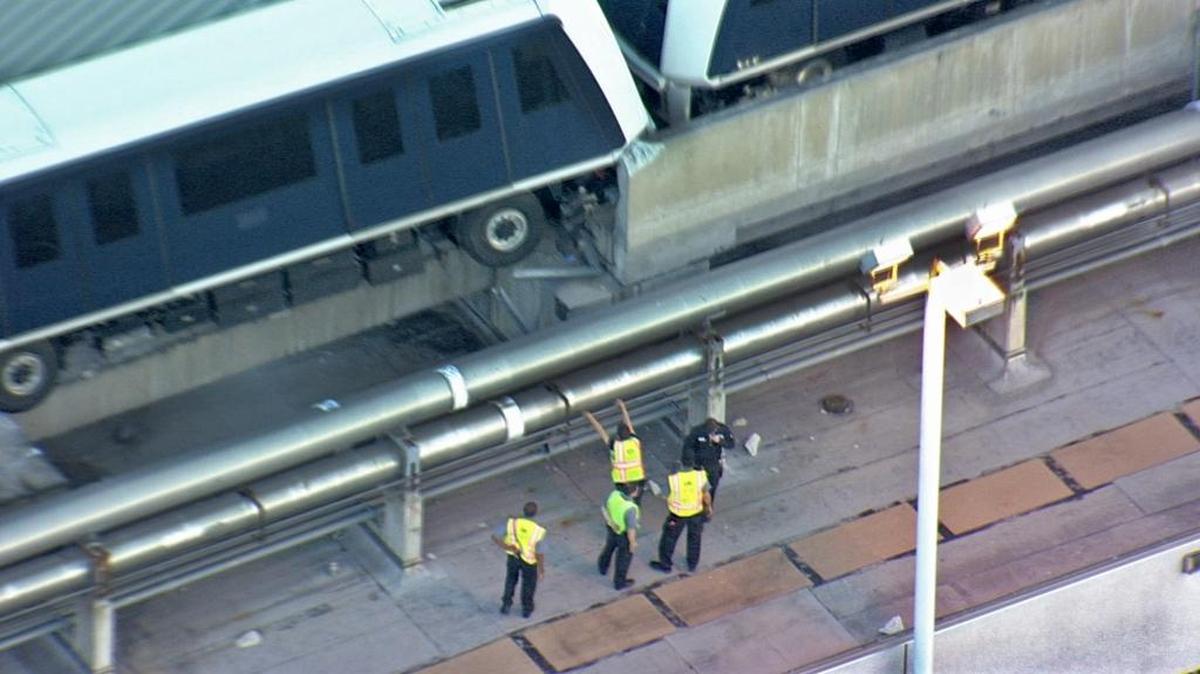 Las autoridades del Aeropuerto Internacional de Miami inspeccionan los vagones del Skytrain que se descarrilaron la madrugada del martes.
