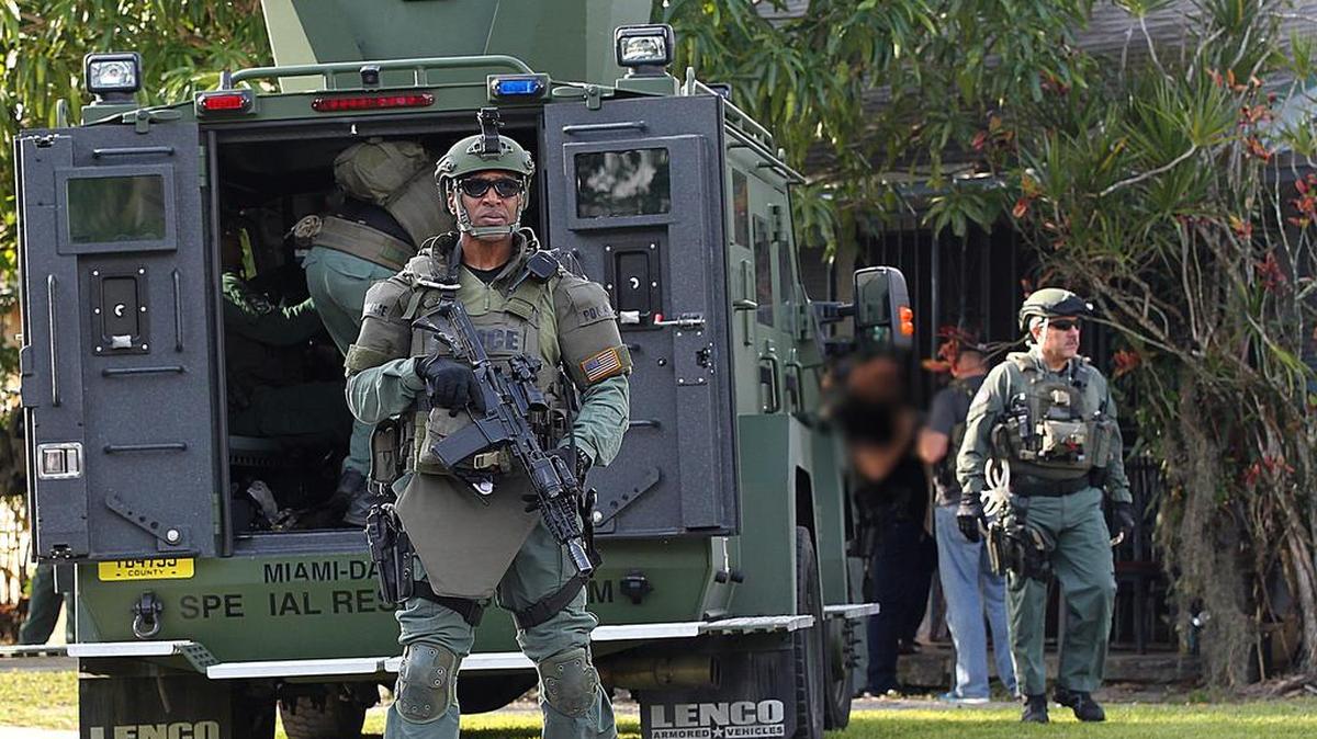 Miembros del Departamento de Policía de Miami-Dade haciendo guardia junto a una casa en el suroeste del condado donde tuvo lugar una redada que resultó en arrestos e incautación de heroína el 15 de diciembre del 2016.