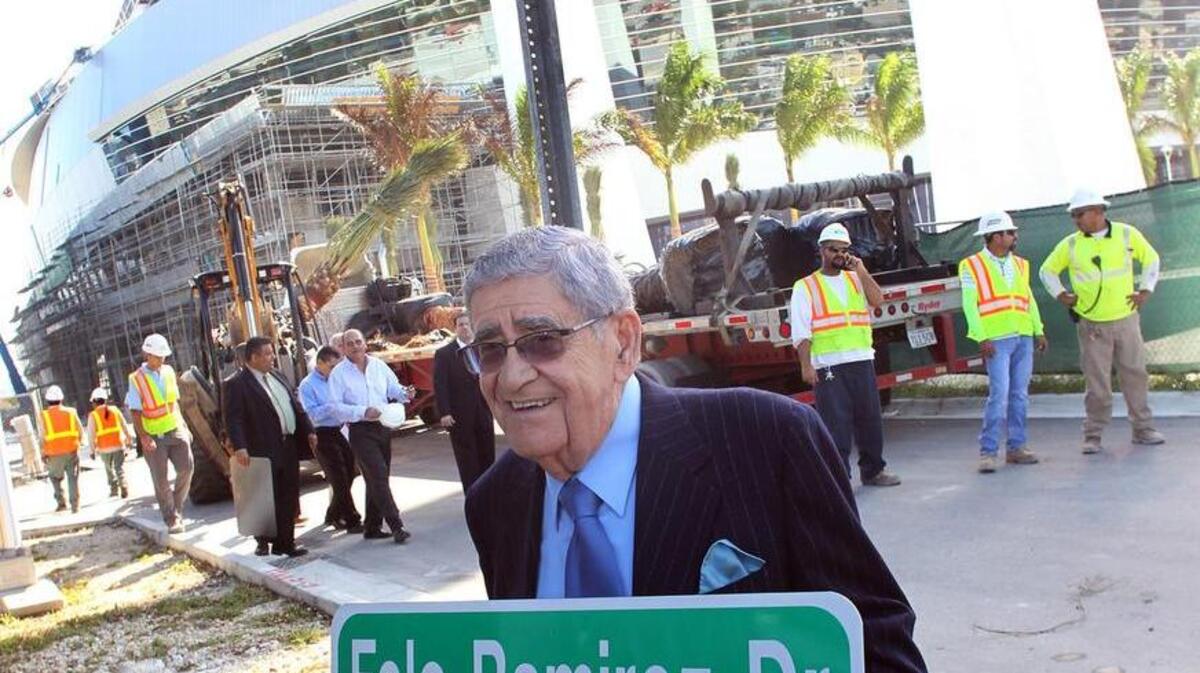 La voz de los Marlins en español, el locutor Rafael “Felo” Ramírez, posa con la señal de una calle que lleva su nombre. Foto de archivo.
