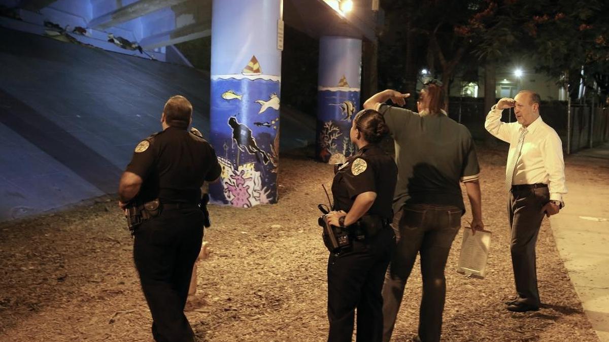 
Ronald L. Book (der.) guía a un grupo de apoyo y a la policía de Miami, el jueves, hacia un pequeño grupo de desamparados debajo de un puente.


