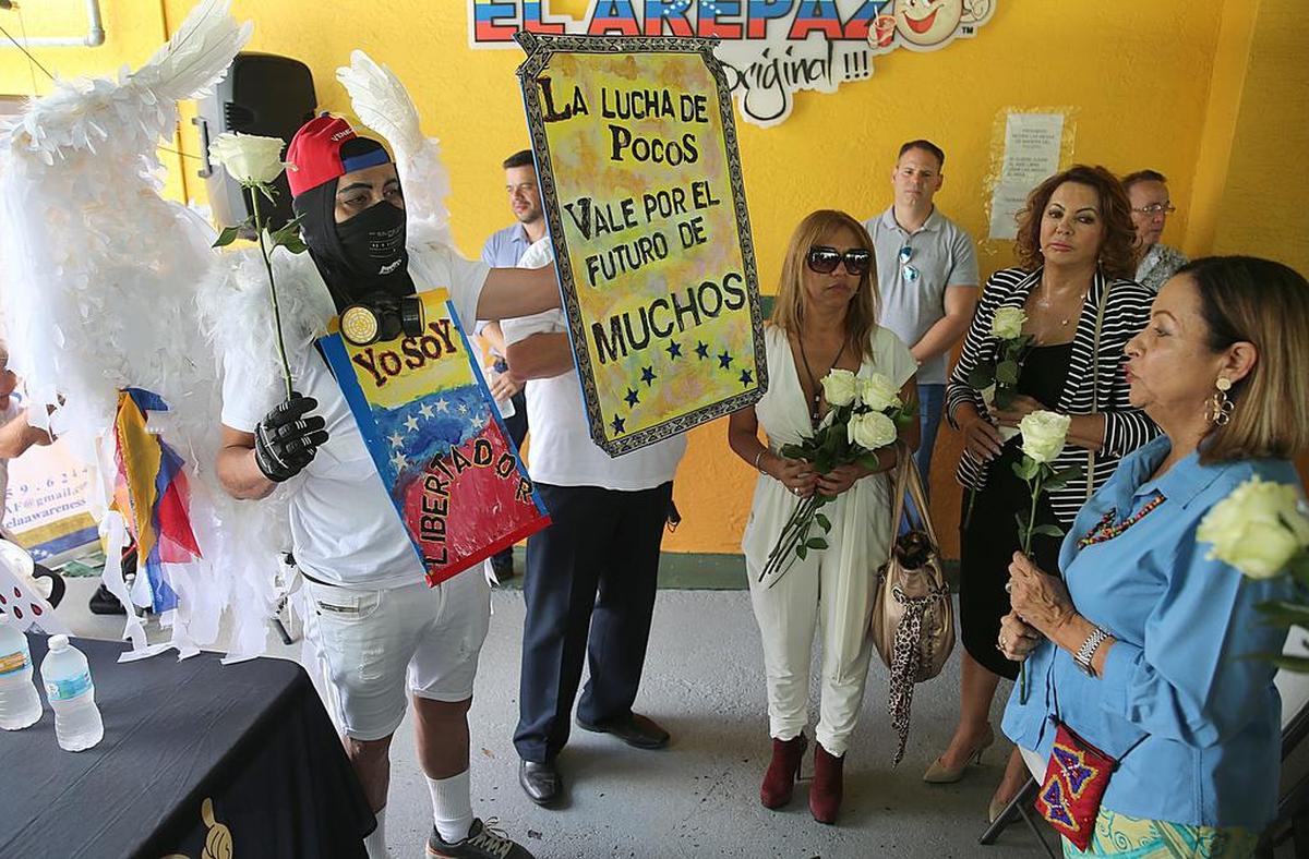 Alexis Rivero (izq.) estuvo entre los venezolanos que asistieron a la dedicación del mural pintado por el artista Al Blanco, que honra a las víctimas de las protestas contra la el gobierno de Nicolás Maduro en Venezuela.