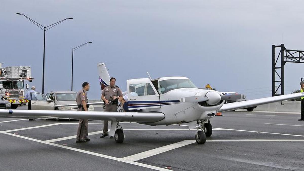 
Oficiales de la Patrulla de Caminos de Florida conversan con Scott Richmond, el piloto que aterrizó de emergencia en la autopista 595, cerca de Davie, Condado Broward. 
