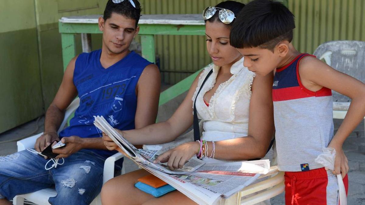 Jóvenes cubanos leen las noticias en un albergue para los migrantes cubuanos en Liberia, al norte de Costa Rica.