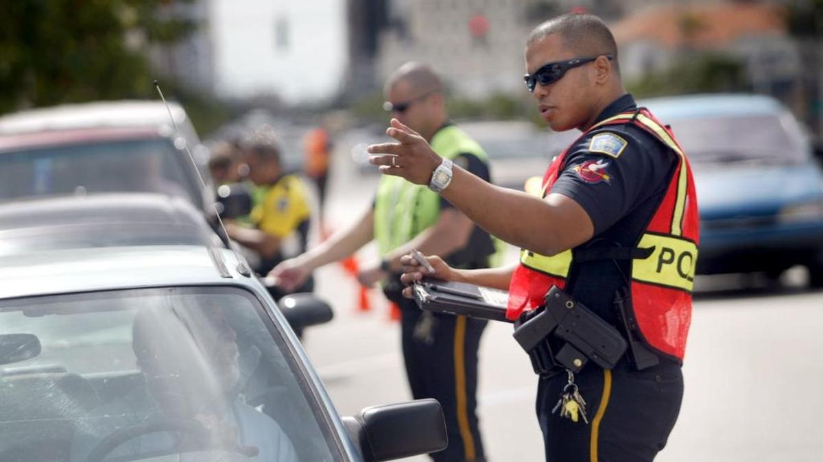 Foto de archivo. Un oficial de la policía de Coral Gables detiene a un conductor en un punto de chequeo de tránsito.