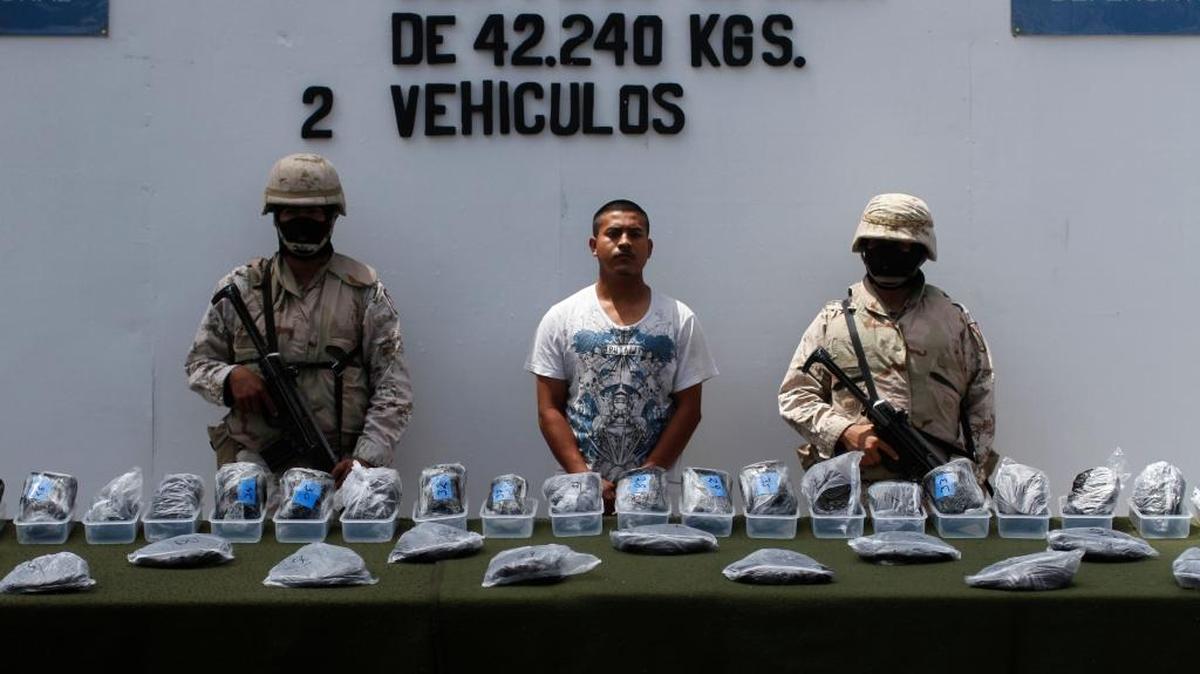 Las autoridades mexicanas muestran a Valentín Jaimes de México frente a paquetes que contienen heroína, durante su presenteción a la prensa en Tijuana, México, en el 2010.