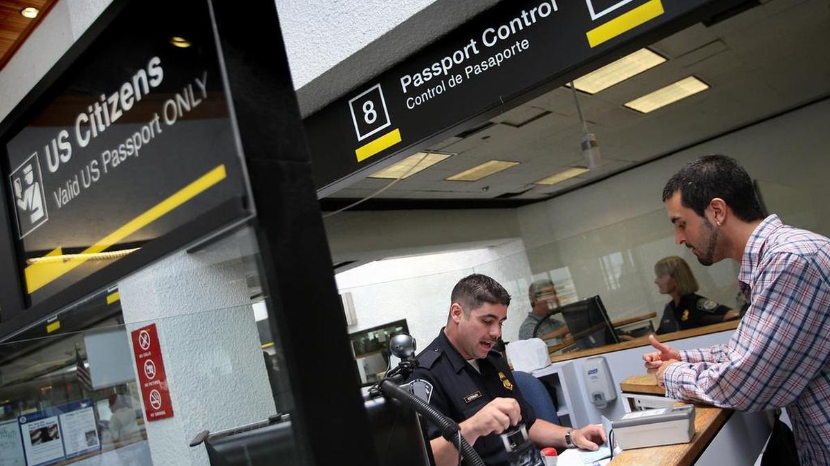 Un pasajero acabado de llegar presenta sus documentos a un funcionario de control de pasaportes en el Aeropuerto Internacional de Miami (MIA) en esta foto de archivo del 2008.