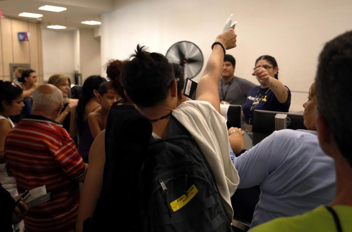 Pasajeros intentan obtener un vuelo el lunes, 25 de septiembre de 2017, en el Aeropuerto Internacional Luis Muñoz Marín en Carolina, Puerto Rico. Puertorriqueños llegaron a Miami en uno de los primeros vuelos que salieron de la isla tras el paso del huracán María para apaciguar la falta de electricidad, aire acondicionado y comunicaciones, e incluso para tratamientos médicos.