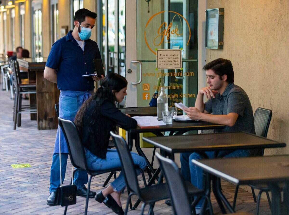 Alonso Escalante, de 33 años, mesero de Ghee Indian Kitchen, toma un pedido de los invitados que visitan el restaurante en Dadeland el miércoles 20 de mayo de 2020.