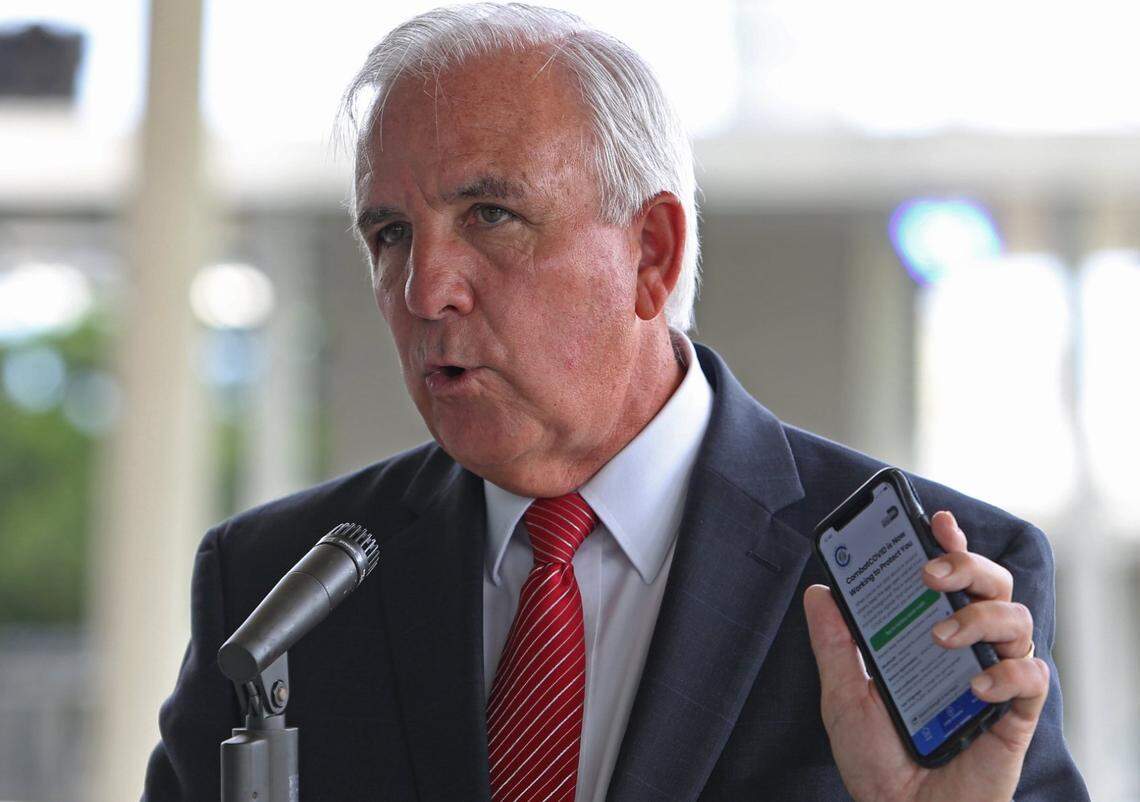 El alcalde de Miami-Dade, Carlos Gimenez, sostiene su teléfono con la aplicación CombatCOVID MDC abierta. Giménez estaba promocionando la nueva aplicación durante una conferencia de prensa donde el gobernador Ron DeSantis, el viernes 11 de septiembre de 2020.