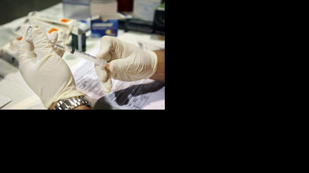 
Un enfermero prepara una vacuna de influenza para ser administrada durante una feria de salud en Miami-Dade en el 2009. 

