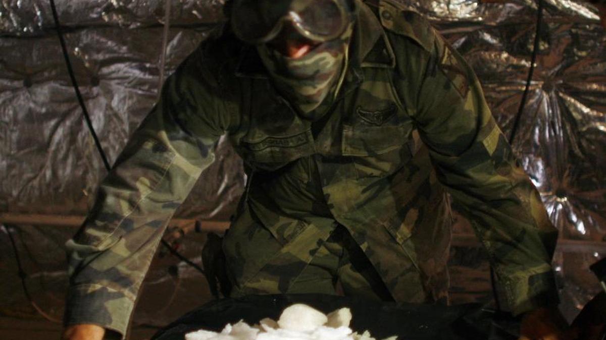 Soldados del Ejército llevan una cubeta llena de drogas sintéticas incautadas en un laboratorio ilícito operado por el cartel de Sinaloa en Durango en México, el lunes 10 de agosto del 2009.