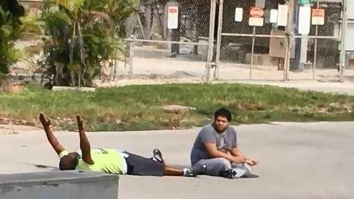 Imagen de video en donde se ve a Charles Kinsey con los brazos en alto en el suelo, pidiendo a la policía que no le dispare a Arnaldo Ríos, un hombre de 27 años con autismo.