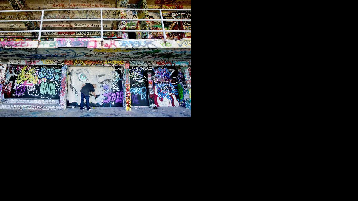 
El pintor Luis Berros pinta una pared bajo las gradas antes del inicio de la conferencia de prensa, este jueves.


