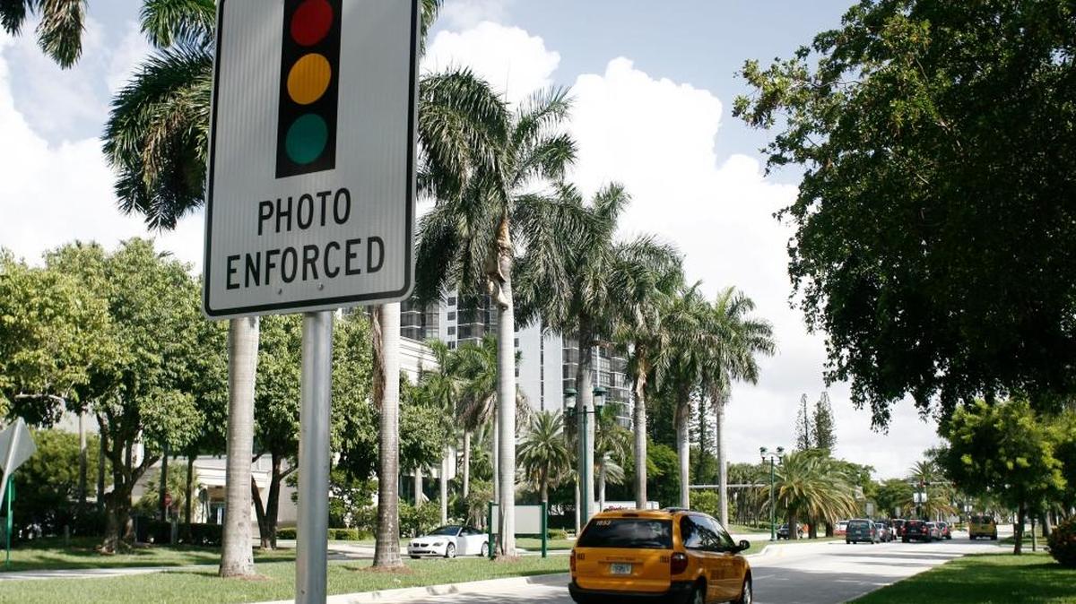 Un aviso alerta a los conductores de la presencia de cámaras en la intersección de West Country Club Drive y Aventura Boulevard..