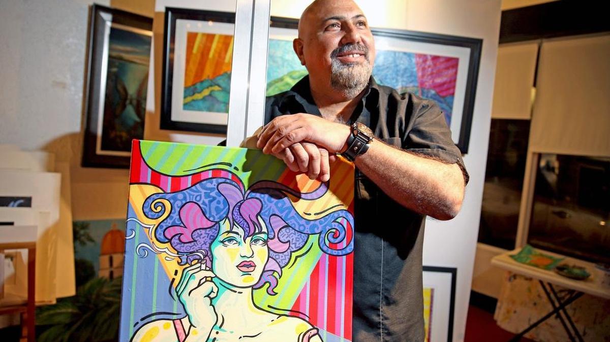 El artista y caricaturista venezolano Carlos Apitz posa con su obra “Mujer con cigarrillo”, en la Galería Adelmo de La Pequeña Habana.