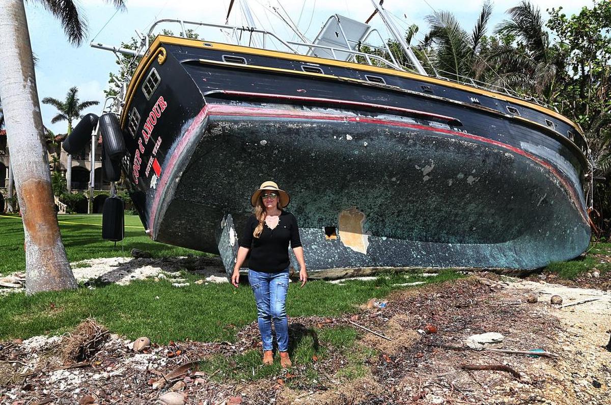 Jessica Ivler, vecina de Coconut Grove, junto a una de las embarcaciones que la tormenta Irma arrastró hasta dejarla en el patio de su propiedad.